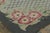 This antique 3x4 hooked rug, circa 1920–1929, features a floral trellis medallion framed by pink blossoms and scrolling...