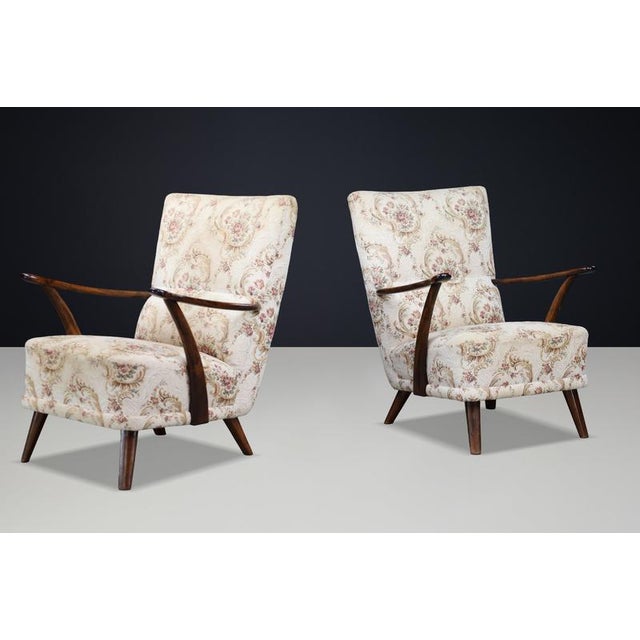 Pair of Italian Art Deco sculptural walnut armchairs from the 1930s, retaining their original floral upholstery in...