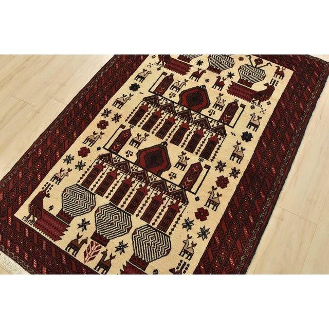 An authentic vintage tribal Baloch rug hand-knotted with fine wool and natural dyes. This nomadic oriental rug features a...