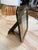 A vintage picture frame with a deep, angular profile, polished metal edges, and a warm brass-tone surround. Its layered...