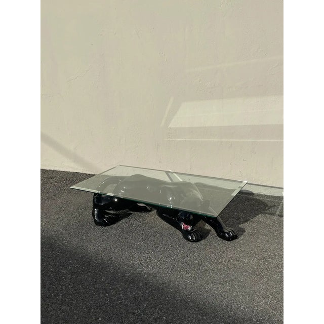 Sculptural panther coffee table with glass top. 1980's style. In excellent condition with light wear from use. Glass top...