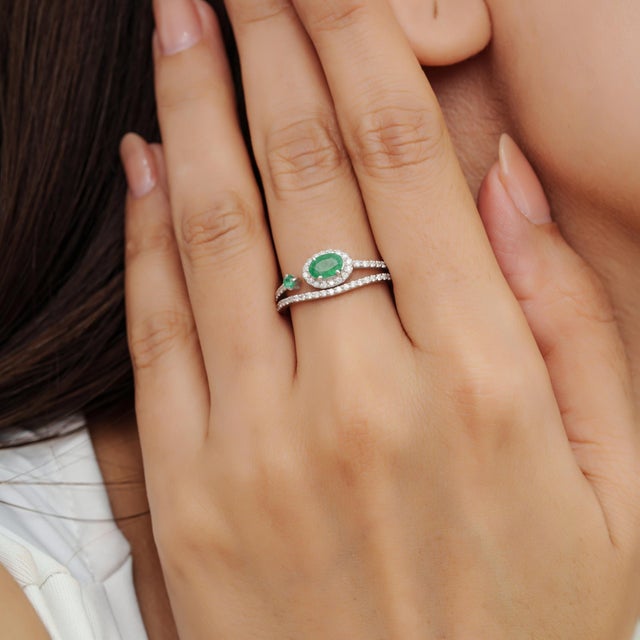 This elegant mid-20th-century style ring is crafted in 925 sterling silver and features a 0.58-carat natural emerald...