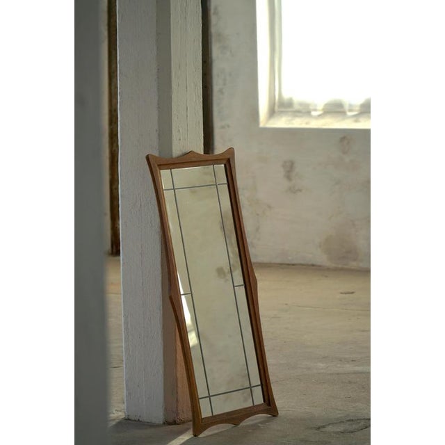 A beautifully proportioned mid-century Danish wall mirror presented in an oak frame and marked on the reverse by Aarhus...