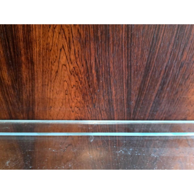 A striking pair of mid-century display cabinets distinguished by their bold architectural form and richly figured...