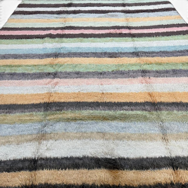 This contemporary Turkish Tulu rug reinterprets traditional Anatolian weaving through a clean, modern lens. Handknotted in...