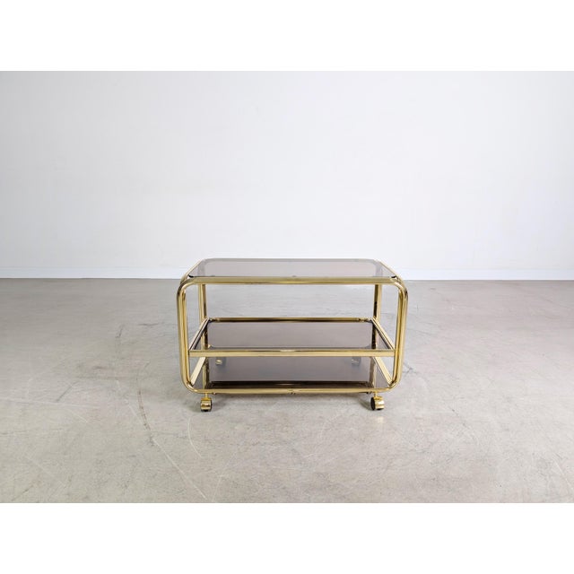 We are offering a beautiful vintage brass and smoked glass serving cart from the 1970s for sale. Made in Italy, this piece...