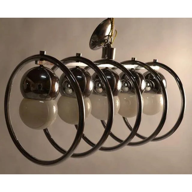 Circular chrome rings surround the large exposed bulbs, five lights make this chandelier capable of illuminating a large...
