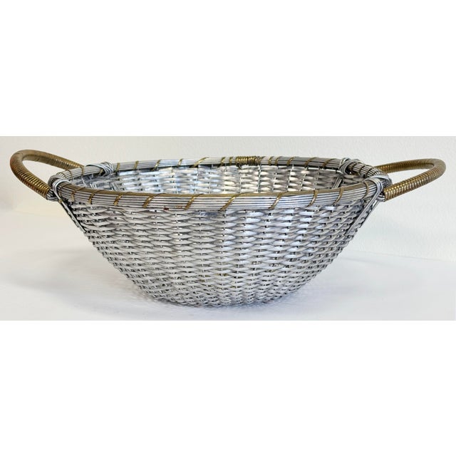 Vintage silver tone aluminum plated basket tray. Round basket with nice ribbed edge detailing and coiled brass handles to...