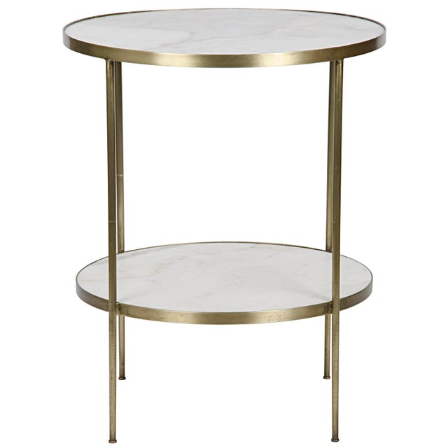 Circular slabs of marble are held aloft by delicate bands of softly burnished metal in this simple side table that...