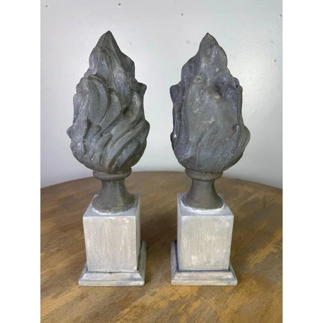 This pair of 19th-century finials features sculptural flame motifs cast in metal, likely zinc, known for its durability...