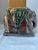 Vintage pair of glazed ceramic elephant sculptures in subtle shades of green, burgundy, and gold. Sculptures are just over...
