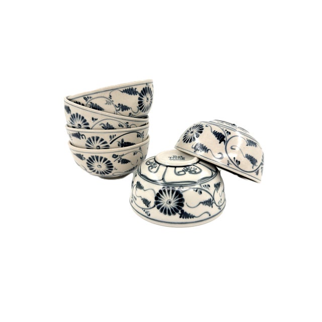 A beautiful set of six hand-painted ceramic bowls from Bat Trang, Vietnam, featuring a richly detailed blue design...
