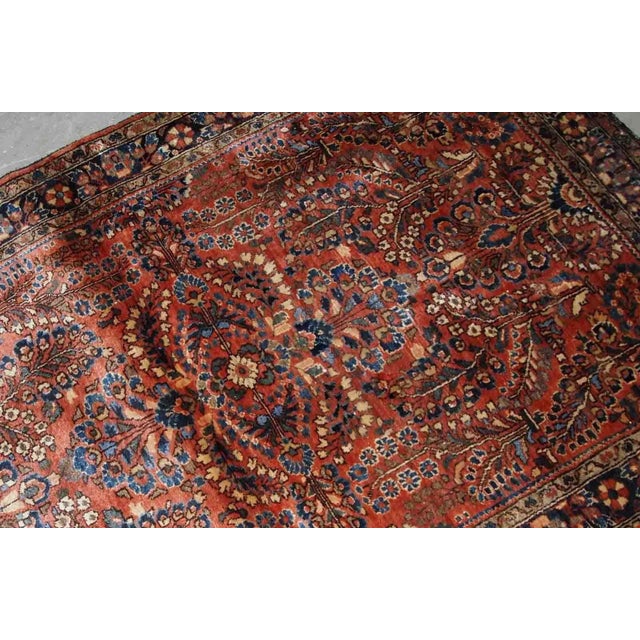 Handmade antique Persian Sarouk rug in original good condition. The rug is from the beginning of 20th century made in red...