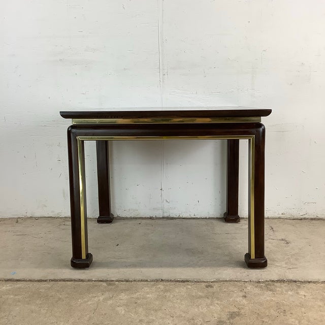 This mid-century Hollywood Regency end table blends natural burl wood with gleaming brass inlay to create a statement of...