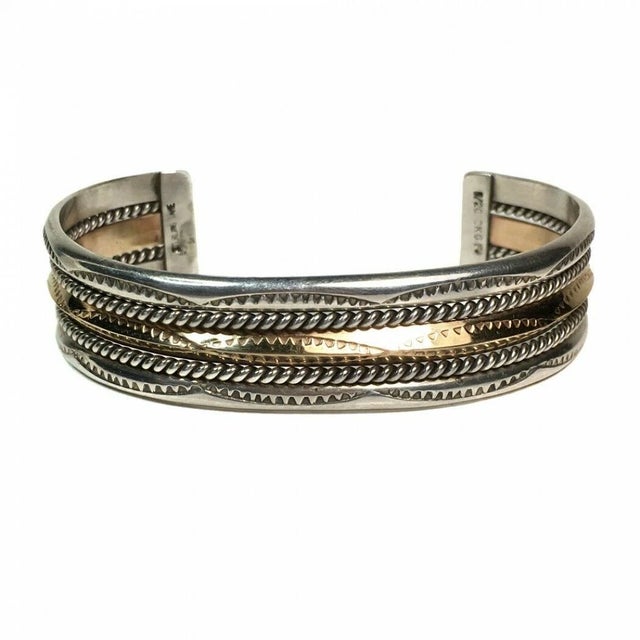 This is a vintage TAHE, NAVAJO sterling and gold fiilled cuff bangle. It is adjustable to fit. It has a twisted rope...