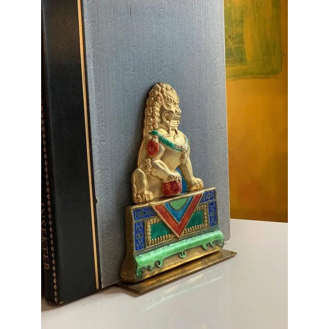 A lovely and vibrant pair of brass bookends with Foo Dog repousse in brilliant enamel colors - well suited for any room...