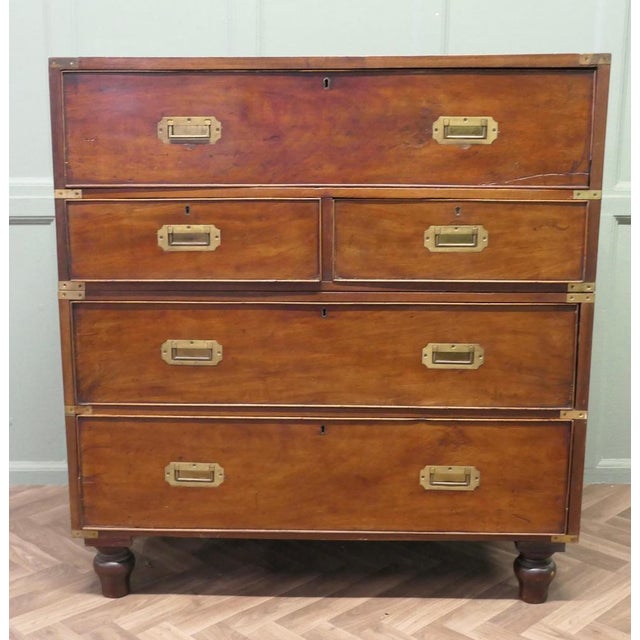 This is a delightful piece, it is made in Teak with campaign style brass corners and inset brass handles on the front and...
