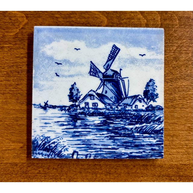 This is a charming vintage hand-painted Delft style ceramic tile featuring a traditional Dutch windmill landscape in...