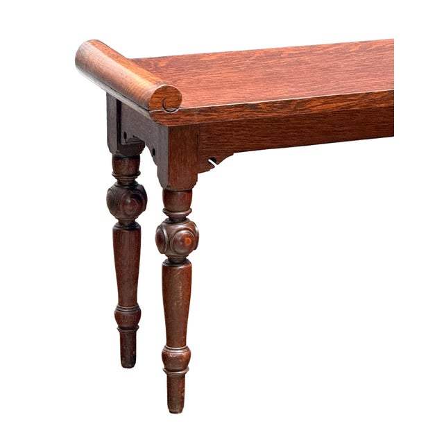 A fine English hall bench or window seat or stool of oak from the Arts and Crafts period, featuring turned bolsters at...