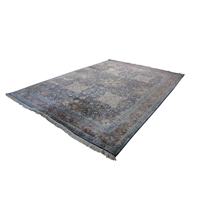This handmade Indian wool area rug features a traditional layout centered around multiple medallions. Woven with a dense,...