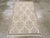 A vintage Turkish Anatolian throw rug. A taupe and beige dot pattern narrow border frames the oyster field of this...