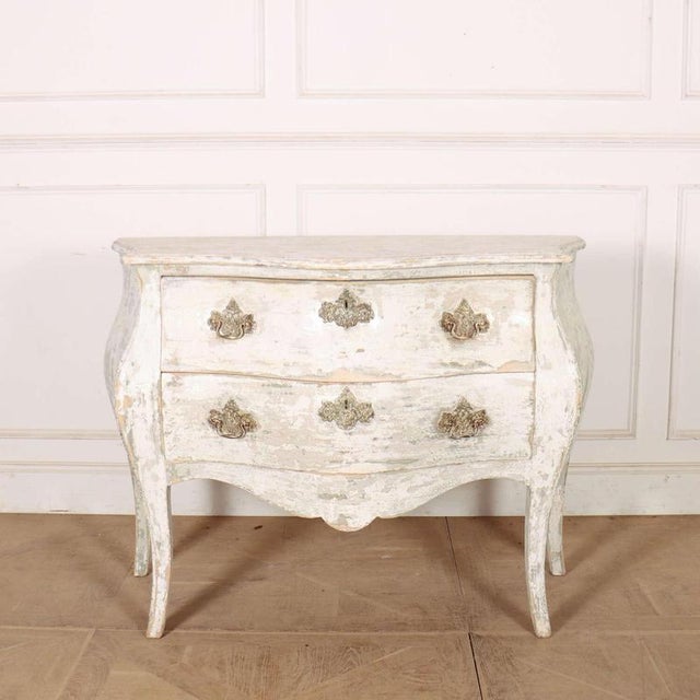 Early 20th century French painted pine bonbe front two drawer commode with good distressed paint. 1910. This piece is...