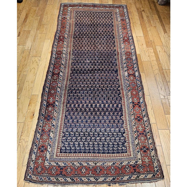 This 19th century Persian Kurdish oversized gallery rug is a striking example of tribal weaving, showcasing a...