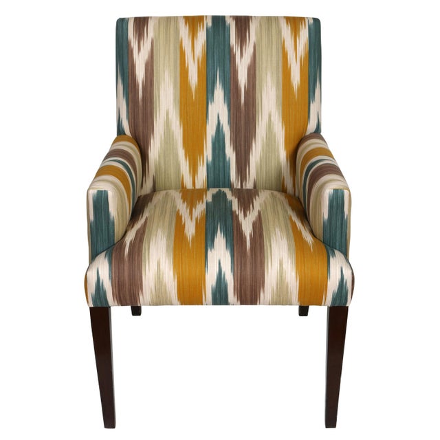 A pair of accent chairs upholstered in a vibrant multicolor ikat fabric from Lee Jofa. The chairs showcase clean lines,...