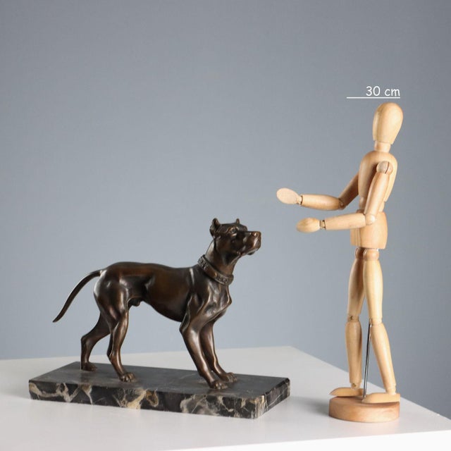 Bronze dog on black marble base. This piece is attributed to the mentioned designer/maker. It has no attribution mark and...