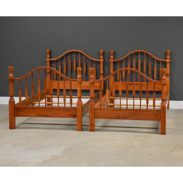 A pair of solid maple twin beds in a light cherry stain with three slats each. Made in USA. Circa 1990’s. Unmarked....