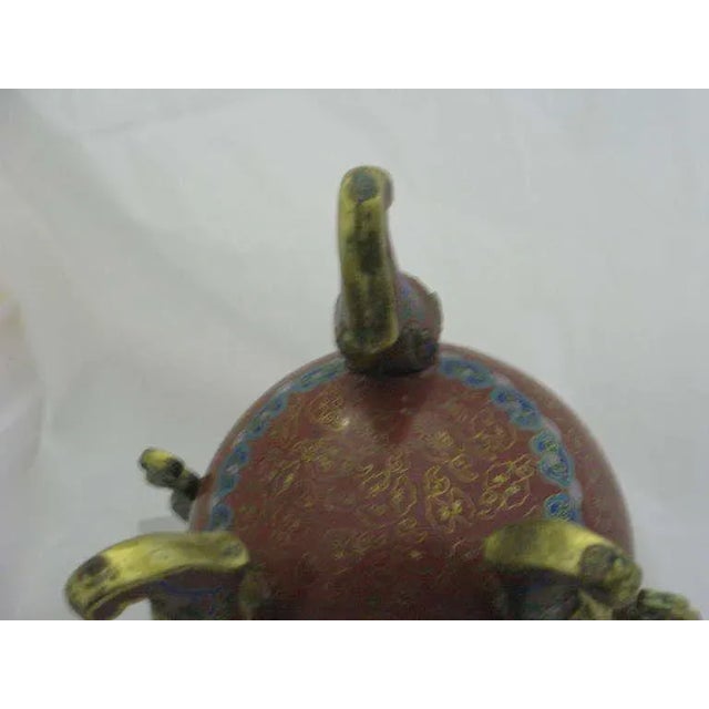 An early 20th century Chinese Republic bronze gilt cloisonne tripod censer on three cabriolet legs emerging from gilt lion...