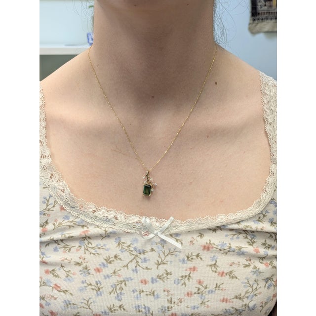 This elegant pendant features a vivid 3.41ct emerald-cut Chrome Tourmaline from Brazil, measuring 10.6 x 7.2mm. Set in 14k...