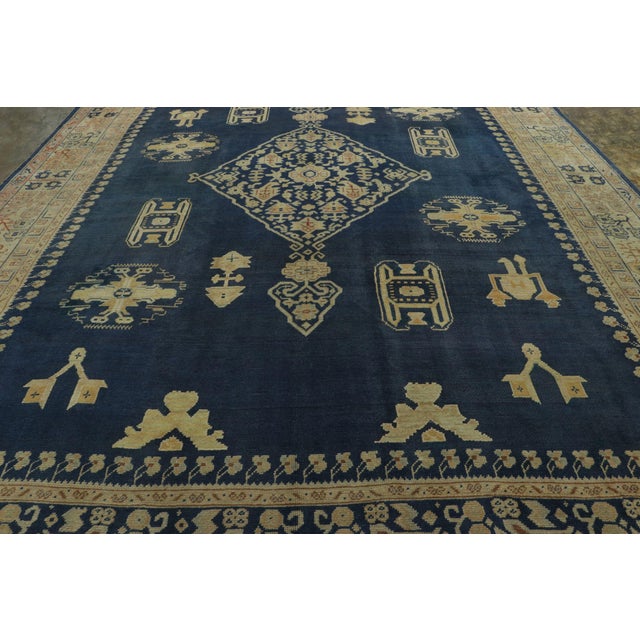 Hand-knotted in high-quality wool and originating from Turkey circa 1950-1960, this vintage 12x17 Oushak rug is part of an...