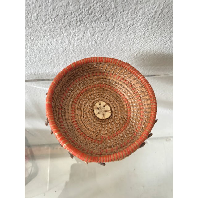 This amazing hand woven basket made out of pine needles features a slice of antler at the center. Unsigned.