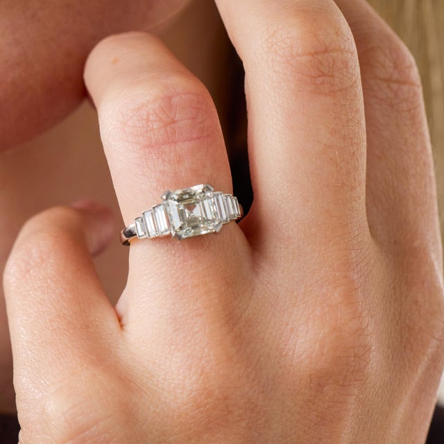 This exceptional Art Deco style engagement ring is centered by a GIA-certified Asscher cut diamond weighing an impressive...