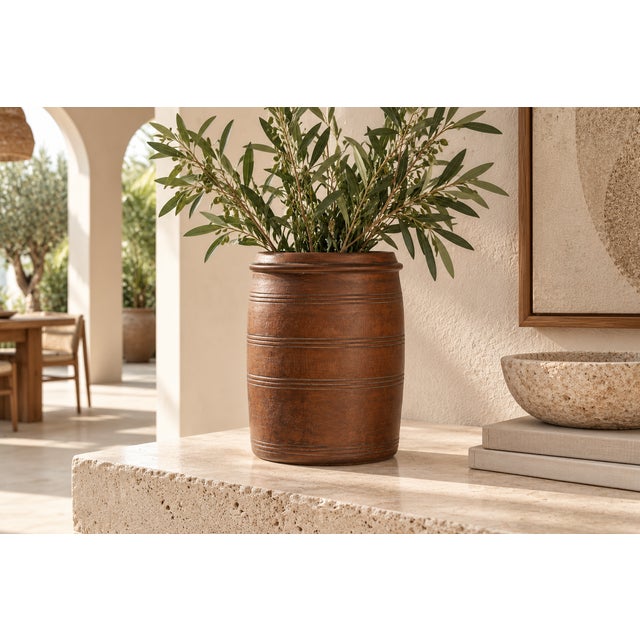 A tall, straight-sided bowl turned from a single warm, reddish-brown wood, with a thick flared lip at the rim and a band...