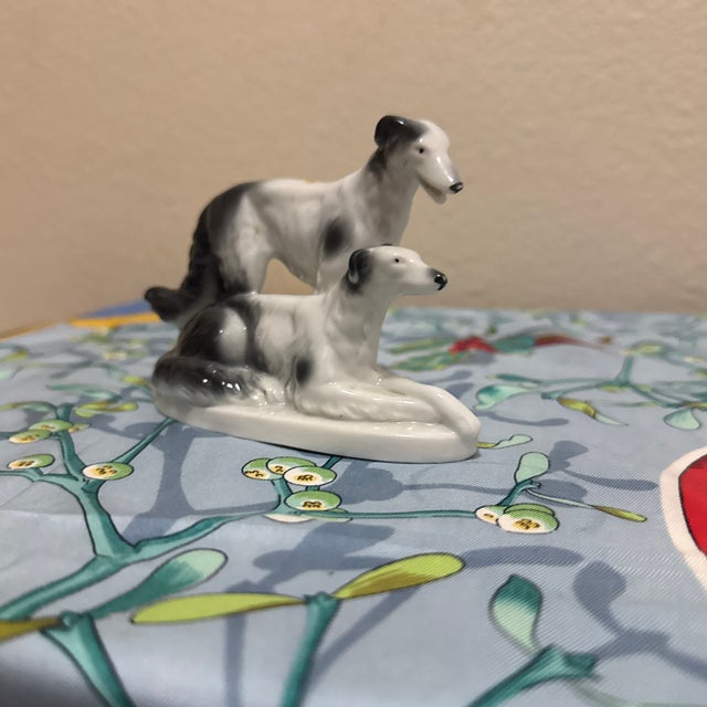 This elegant vintage porcelain figurine features Borzoi (Russian Wolfhounds) in a classic pose, with one dog standing and...