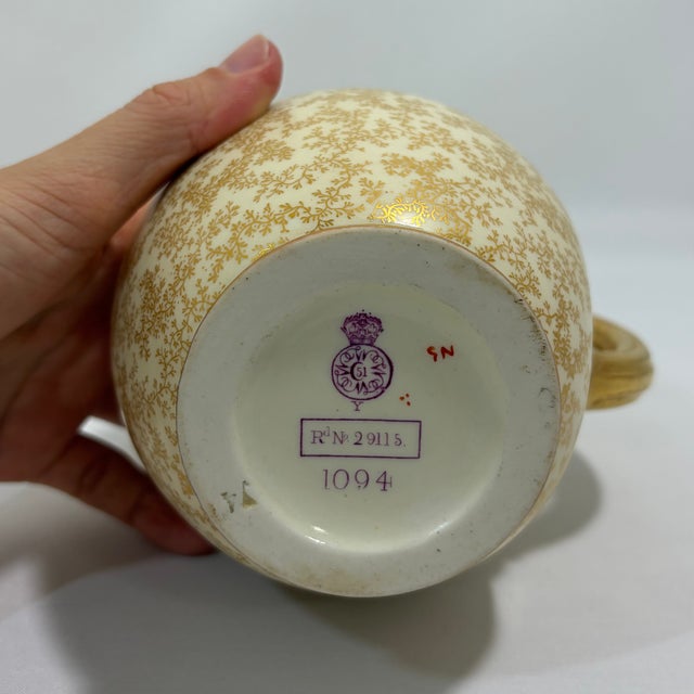 Antique Royal Worcester porcelain jug dating to 1887, featuring an ivory-toned body covered in intricate gilt floral and...