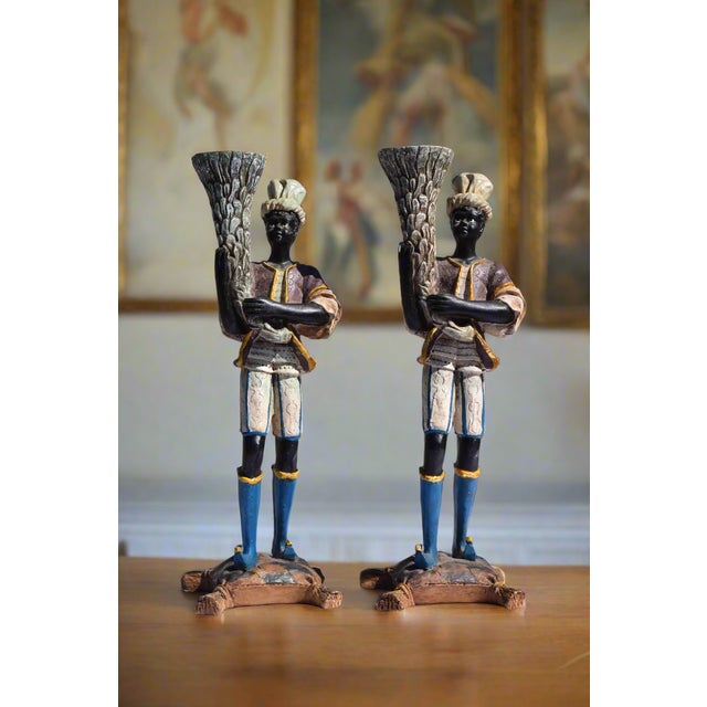 VENETIAN BLACKAMOOR FIGURAL CANDLESTICKS Era: 20th Century Origin: Venice, Italy Material: Painted Composition Material...