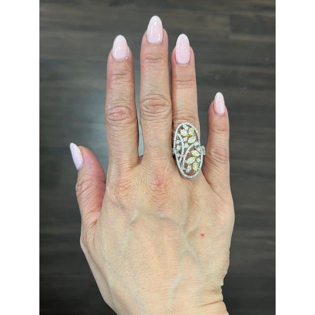 This stunning ring boasts beautiful natural yellow diamonds as the main stones, with a combined total of 131 diamonds. The...