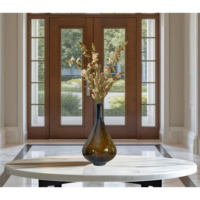 This striking hand-blown Murano-style art glass vase features a commanding 17 ¼-inch height and a 10-inch width, making it...