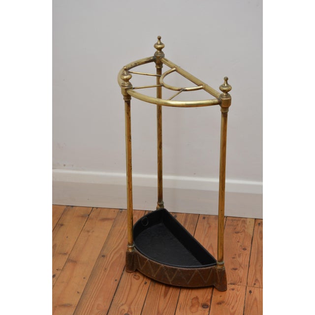 P0332 victorian brass umbrella stand of half moon design with three decorative finials, five umbrella and walking cane...