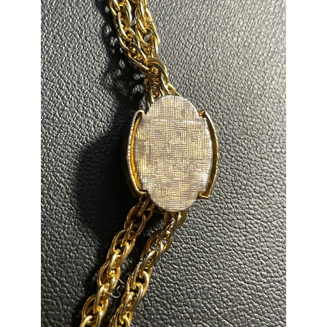 Victorian Revival lariat necklace offers both timeless charm and clever versatility. Crafted with a gleaming gold-tone...