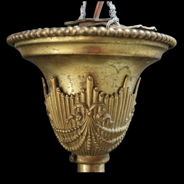 An antique Neoclassical style brass pendant light, in the manner of Bradley & Hubbard, dating to approximately 1910. This...