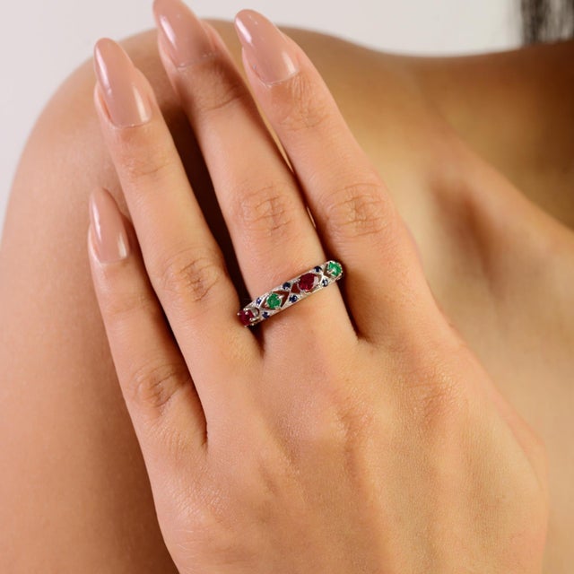 This antique-style half eternity band ring is crafted in solid silver and features a beautiful mix of emerald, ruby, and...