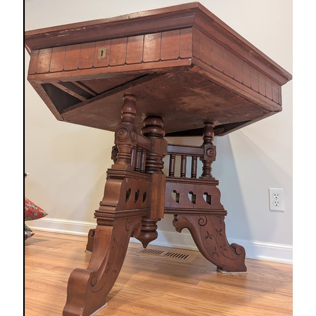 A hexagonal center table in the Eastlake style, tri-part center pedestal with carved floral detail along with elaborate...
