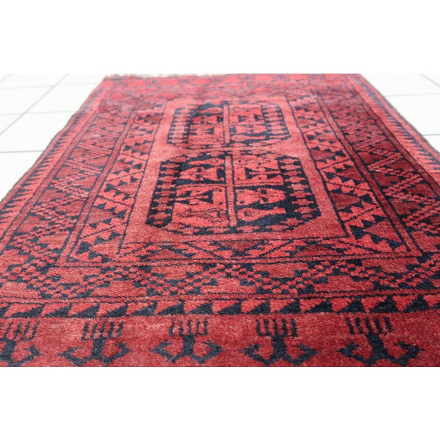 Immerse your living space in the rich history and artistry of our Handmade Vintage Afghan Ersari Rug from the 1940s....