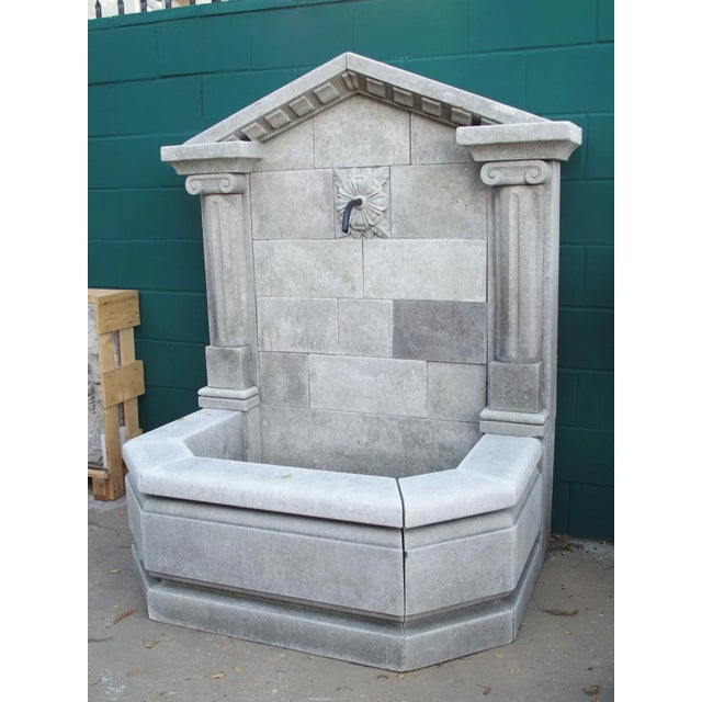 Hand-carved in Northern Italy in the Neoclassical style, this limestone wall fountain features a triangular pediment...