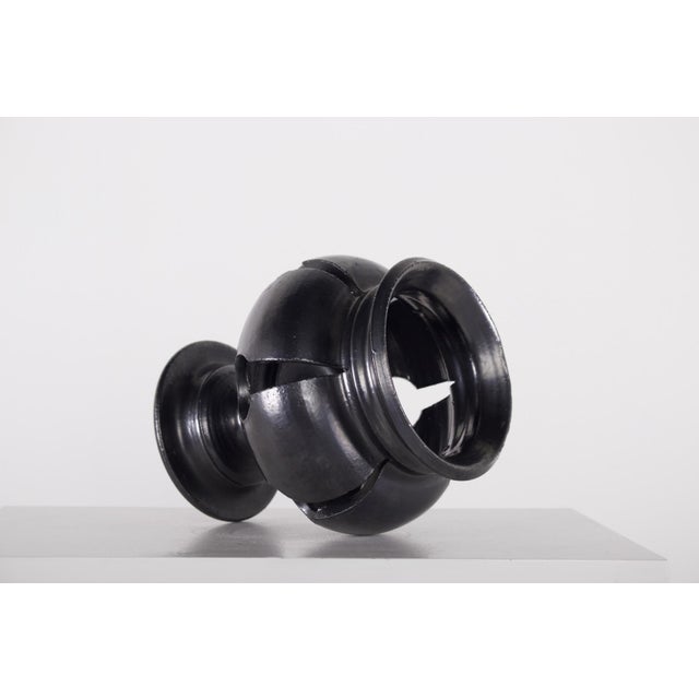 A black terracotta candle holder, baluster-shaped on a pedestal, decorated with openwork, made in Vallauris around 1975....