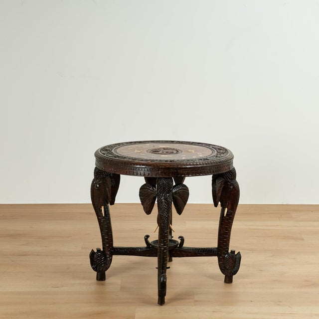 Impressive antique Anglo Indian table handcrafted in teak featuring a top with a carved elephant center medallion , inlaid...